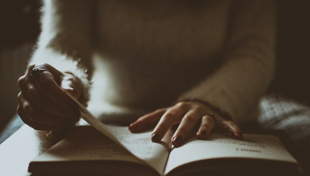 photo of person flipping book page